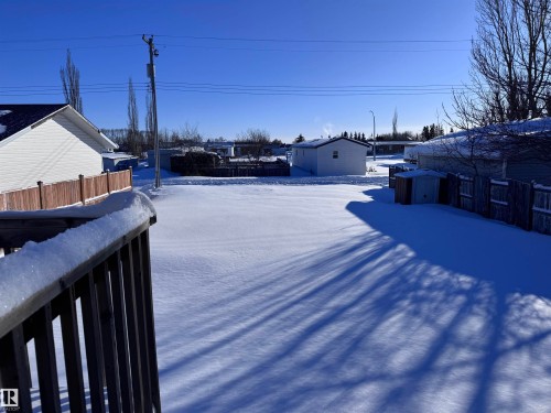 Yard layered in snow featuring a storage shed and a residential view - 4919 49 Avenue, Vimy, AB - Outdoor