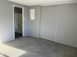 Unfurnished bedroom featuring carpet floors, a textured ceiling, and ensuite bathroom - 