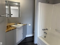 Full bathroom featuring vanity, tub / shower combination, and dark wood-style floors - 