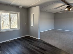 Unfurnished room with ceiling fan, dark wood-type flooring, and beam ceiling - 