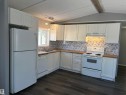Kitchen featuring white appliances, butcher block countertops, white cabinetry, and dark wood-style flooring - 8 Evergreen Park Drive, Edmonton, AB  - Indoor Photo Showing Kitchen With Double Sink 
