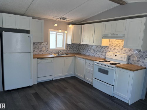 Kitchen with white appliances, wood counters, and white cabinetry - 8 Evergreen Park Drive, Edmonton, AB - Indoor Photo Showing Kitchen With Double Sink