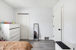 Bedroom with light wood finished floors, a closet, and a textured ceiling - 