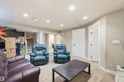 Living area with light carpet and recessed lighting - 