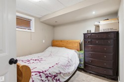 Bedroom with light colored carpet and a paneled ceiling - 