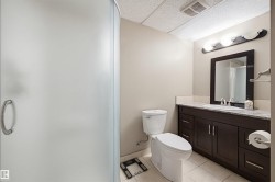 Full bath featuring a drop ceiling, vanity, light tile patterned floors, and a shower with shower door - 