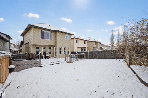 Snow covered house featuring a fenced backyard, a residential view, and a deck - 4020 157A Avenue, Edmonton, AB - Outdoor