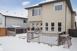 Snow covered back of property featuring a deck - 