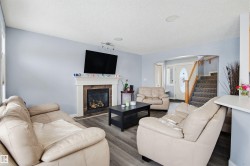 Living area featuring arched walkways, a fireplace, a textured ceiling, wood finished floors, and rail lighting - 