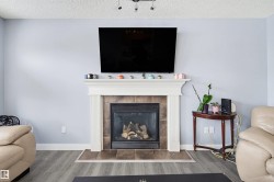 Detailed view of a textured ceiling, wood finished floors, and a tiled fireplace - 