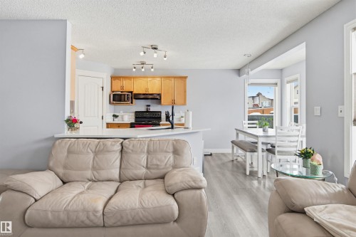 Living room featuring light wood-type flooring and a textured ceiling - 4020 157A Avenue, Edmonton, AB - Indoor Photo Showing Living Room