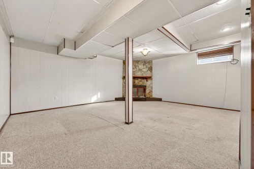 Below grade area featuring wooden walls, carpet, a fireplace, and a paneled ceiling - 4645 115 Avenue, Edmonton, AB - Indoor Photo Showing Other Room