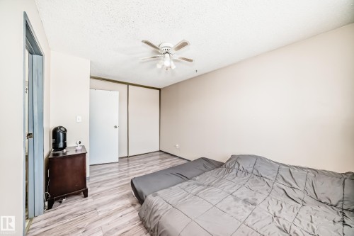 Bedroom featuring light wood finished floors, a closet, a textured ceiling, and a ceiling fan - 214A Warwick Road, Edmonton, AB - Indoor Photo Showing Bedroom