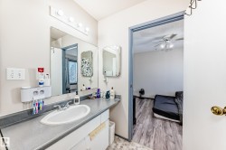 Bathroom with vanity, a ceiling fan, and light wood-type flooring - 