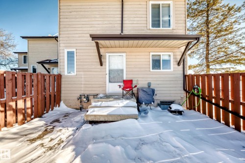 Snow covered rear of property with a fenced backyard - 214A Warwick Road, Edmonton, AB - Outdoor With Exterior