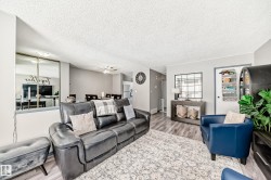 Living area featuring wood finished floors, a textured ceiling, and ceiling fan - 
