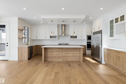 Dual tone kitchen with dual tone cabinets, open shelves, stainless steel appliances, a kitchen island, and hanging light fixtures - 6871 Knox Loop Sw, Edmonton, AB - Indoor Photo Showing Kitchen