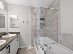 Bathroom featuring double vanity, a shower stall, and a bath - 