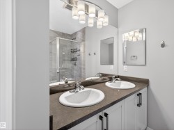Bathroom featuring double vanity and a shower stall - 