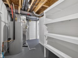 Below grade area featuring electric water heater and heating unit - 