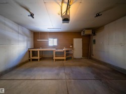 Garage featuring a heating unit, a garage door opener, and a workshop area - 