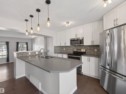 Kitchen featuring stainless steel appliances and white cabinets. - 