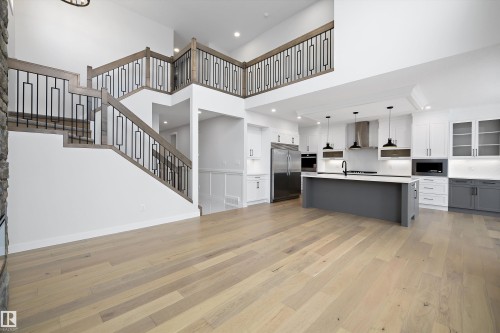 Kitchen with open floor plan, light countertops, hanging light fixtures, stainless steel appliances, and an island with sink - 718 Elderberry Close Nw, Edmonton, AB - Indoor Photo Showing Kitchen