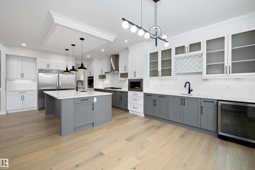Kitchen with tasteful backsplash, two tone color scheme, wine cooler, pendant lighting, and built in appliances - 718 Elderberry Close Nw, Edmonton, AB - Indoor Photo Showing Kitchen With Upgraded Kitchen