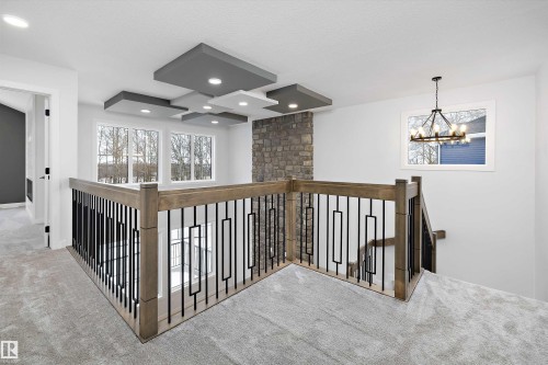 Hallway with an upstairs landing, carpet, and suspended lighting - 718 Elderberry Close Nw, Edmonton, AB - Indoor Photo Showing Other Room