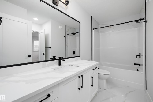 Bathroom featuring vanity, shower / washtub combination, and light marble finish flooring - 718 Elderberry Close Nw, Edmonton, AB - Indoor Photo Showing Bathroom