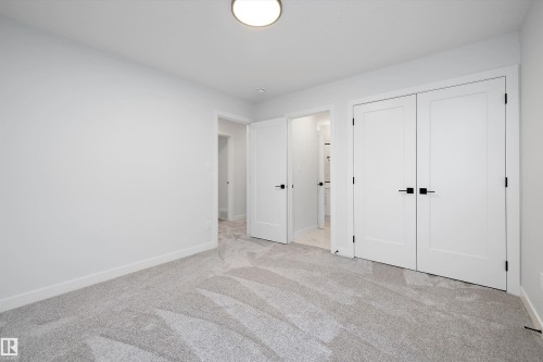 Unfurnished bedroom featuring light carpet and a closet - 718 Elderberry Close Nw, Edmonton, AB - Indoor Photo Showing Other Room
