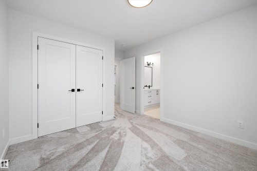 Unfurnished bedroom featuring ensuite bathroom, light colored carpet, and a closet - 718 Elderberry Close Nw, Edmonton, AB - Indoor Photo Showing Other Room