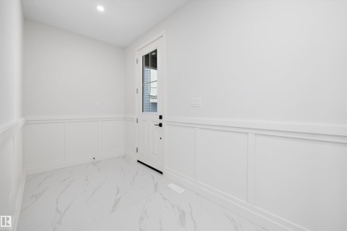 Entryway featuring a decorative wall, wainscoting, marble look tiles, and recessed lighting - 718 Elderberry Close Nw, Edmonton, AB - Indoor Photo Showing Other Room