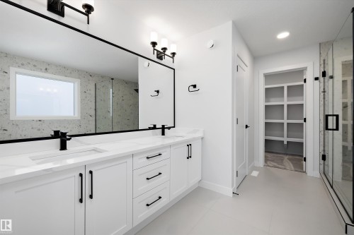 Full bathroom featuring double vanity, a walk in closet, a marble finish shower, and recessed lighting - 718 Elderberry Close Nw, Edmonton, AB - Indoor Photo Showing Bathroom