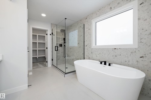 Full bath with a marble finish shower, a spacious closet, a freestanding bath, and vanity - 718 Elderberry Close Nw, Edmonton, AB - Indoor Photo Showing Bathroom