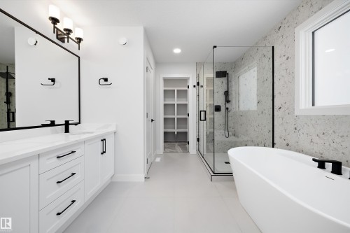Full bathroom with a marble finish shower, double vanity, a freestanding bath, and a spacious closet - 718 Elderberry Close Nw, Edmonton, AB - Indoor Photo Showing Bathroom