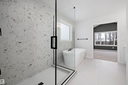 Bathroom featuring a marble finish shower, a freestanding tub, light tile patterned floors, and light colored carpet - 718 Elderberry Close Nw, Edmonton, AB - Indoor Photo Showing Bathroom