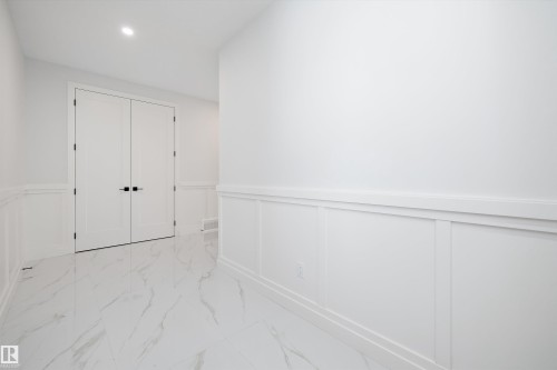 Unfurnished bedroom with a wainscoted wall, light marble finish flooring, a decorative wall, a closet, and recessed lighting - 718 Elderberry Close Nw, Edmonton, AB - Indoor Photo Showing Other Room
