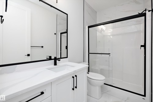 Full bath featuring vanity, a stall shower, and light marble finish flooring - 718 Elderberry Close Nw, Edmonton, AB - Indoor Photo Showing Bathroom