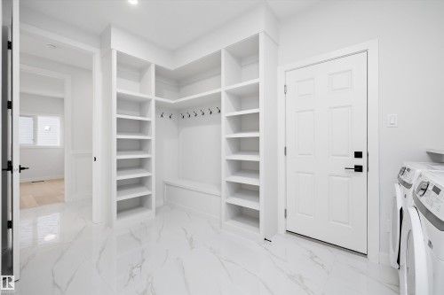 Walk in closet with light marble finish flooring and independent washer and dryer - 718 Elderberry Close Nw, Edmonton, AB - Indoor Photo Showing Other Room