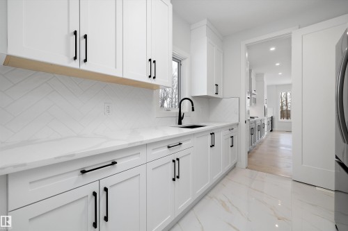 Kitchen with light stone counters, white cabinetry, plenty of natural light, and recessed lighting - 718 Elderberry Close Nw, Edmonton, AB - Indoor Photo Showing Kitchen