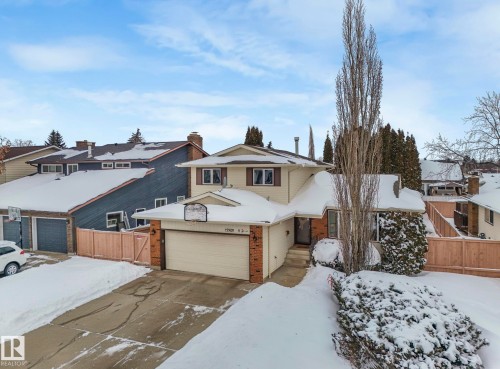View of front of house with brick siding, a residential view, driveway, and an attached garage - 15909 112 B Street Nw, Edmonton, AB - Outdoor