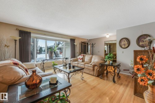 Living area with wood-type flooring and a textured ceiling - 15909 112 B Street Nw, Edmonton, AB - Indoor Photo Showing Living Room