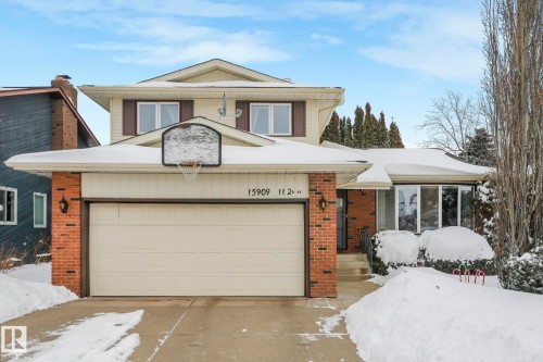 View of front facade featuring brick siding, concrete driveway, and an attached garage - 15909 112 B Street Nw, Edmonton, AB - Outdoor With Facade