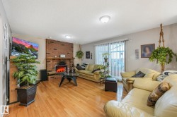 Living room featuring a textured ceiling, wood-type flooring, and a fireplace - 