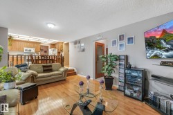Living room featuring light wood-type flooring and a textured ceiling - 