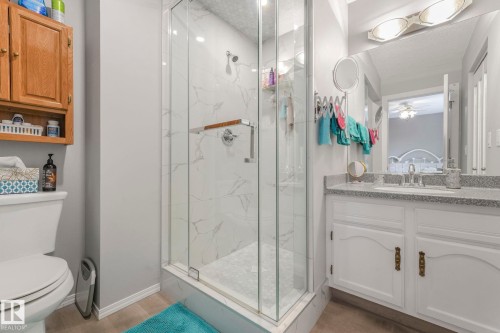 Full bath with vanity, a marble finish shower, and a textured ceiling - 15909 112 B Street Nw, Edmonton, AB - Indoor Photo Showing Bathroom