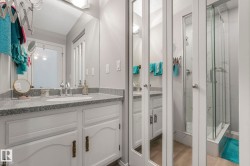 Bathroom featuring vanity, a marble finish shower, and a textured ceiling - 