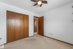 Unfurnished bedroom with light colored carpet, a closet, a ceiling fan, and a textured ceiling - 