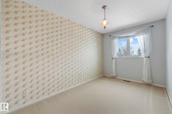 Unfurnished room with wallpapered walls, carpet flooring, and a textured ceiling - 